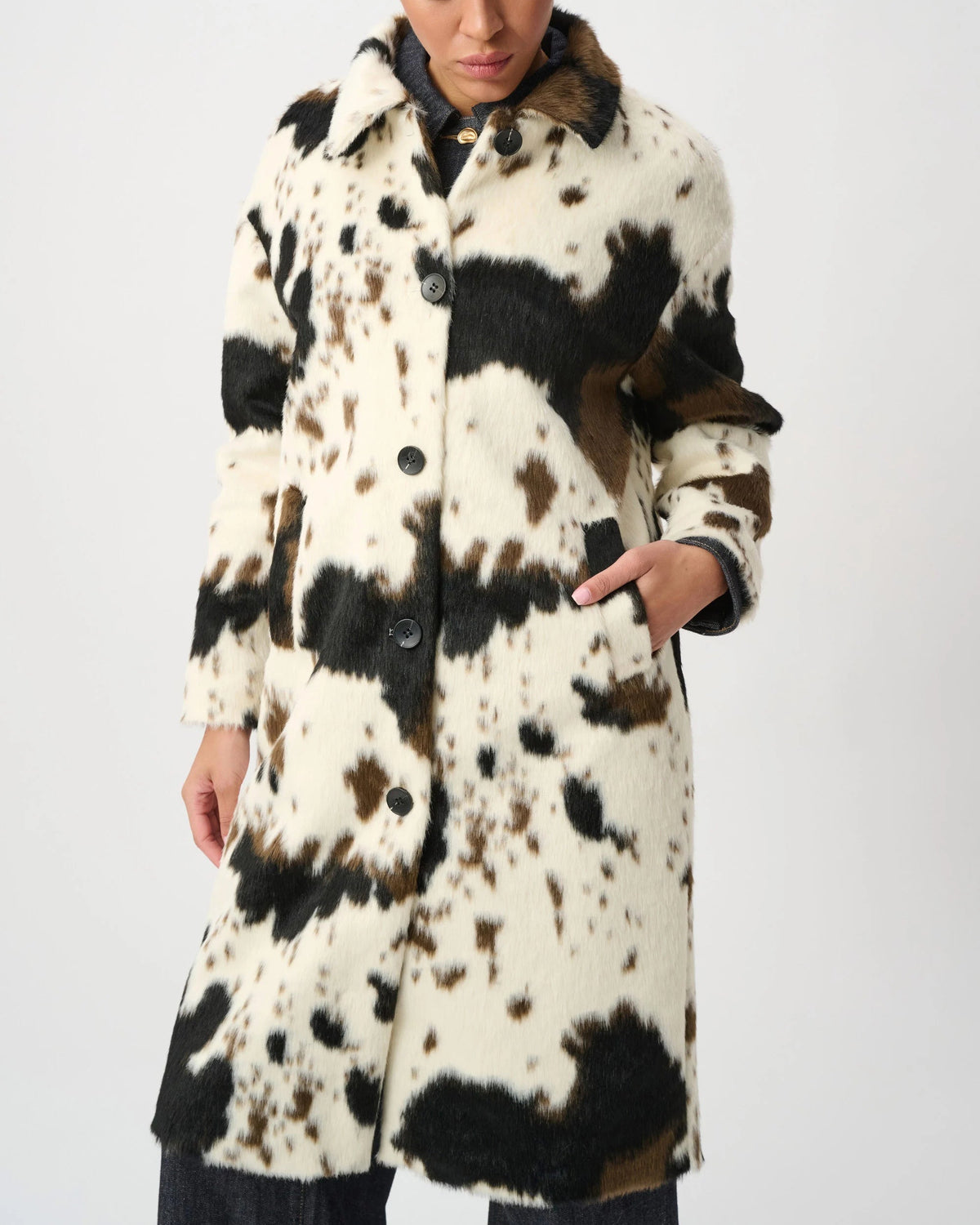 Woman wearing a cow print jacket in front of a white background.