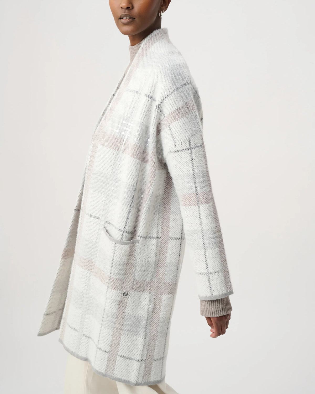 Woman wearing a light gray checkered coat on a white background