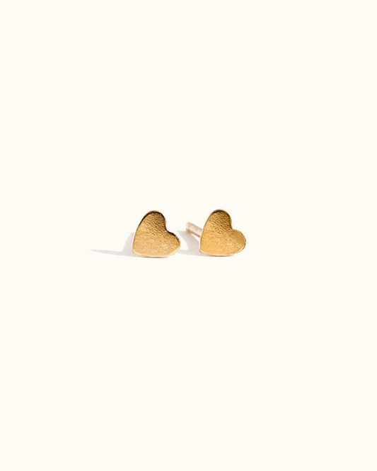 Gold heart-shaped earrings on a white background