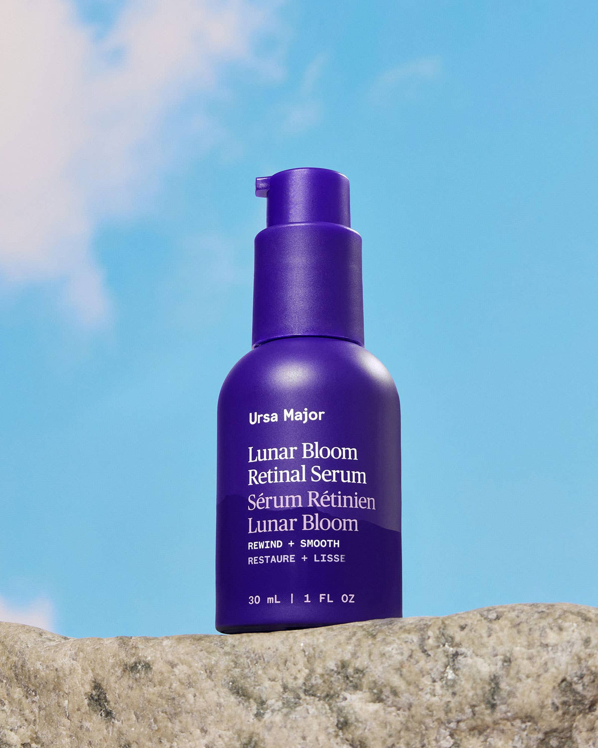 Purple Ursa Major Lunar Bloom Retinal Serum bottle against a blue sky background