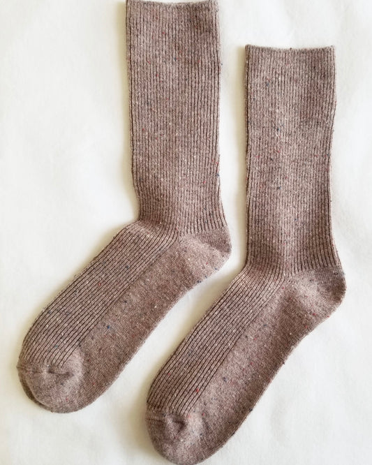 Mauve wool socks laid out on a white background