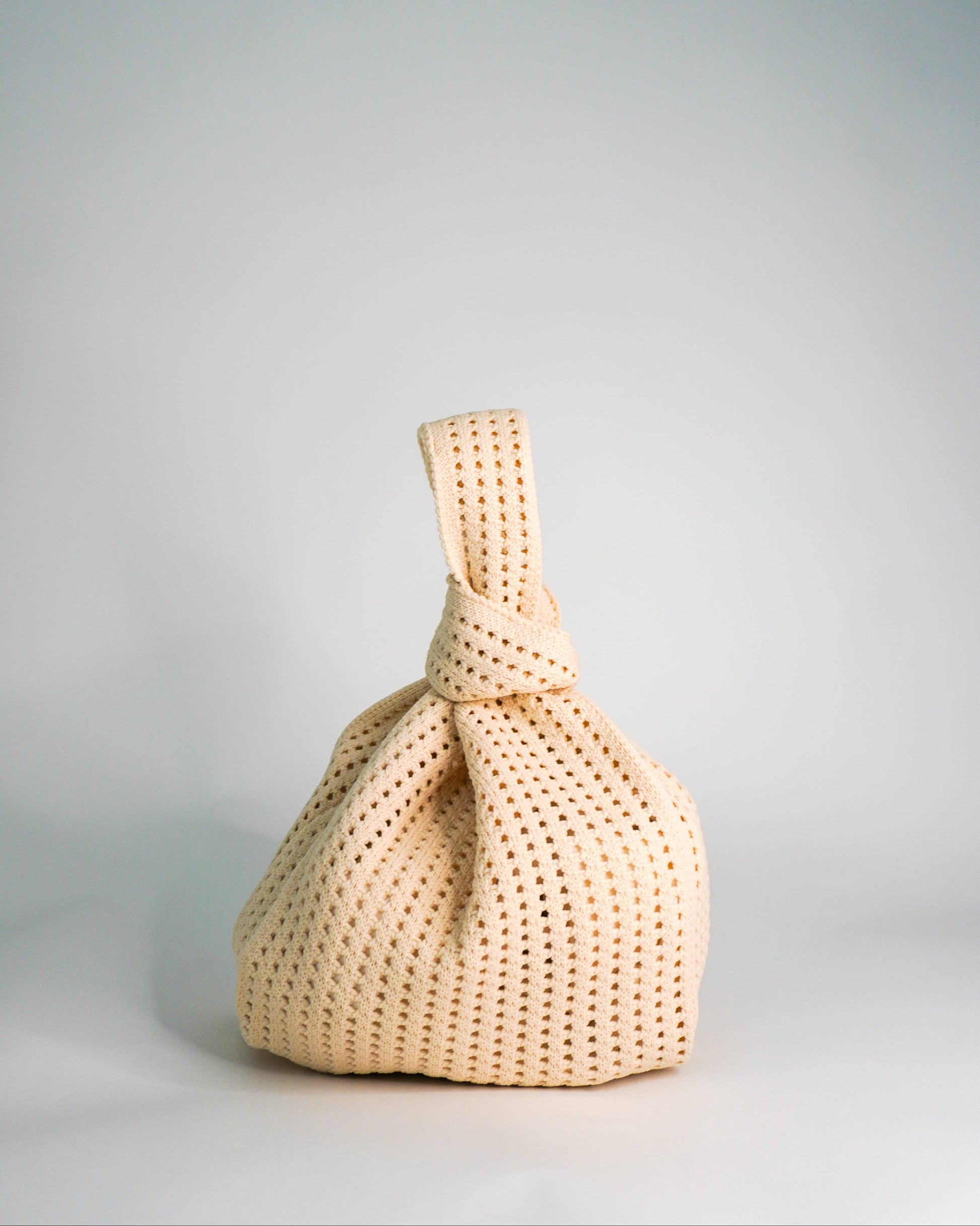 Beige woven bag on a light gray background