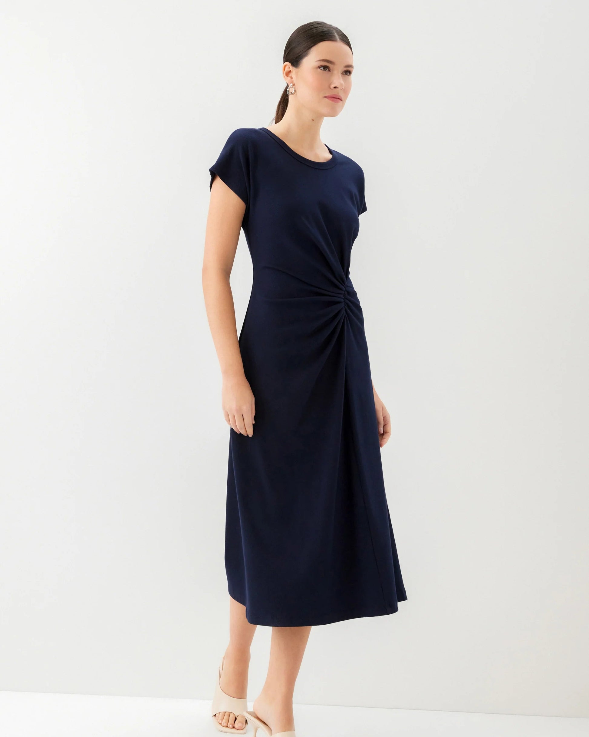 Woman wearing a navy blue dress on a white background