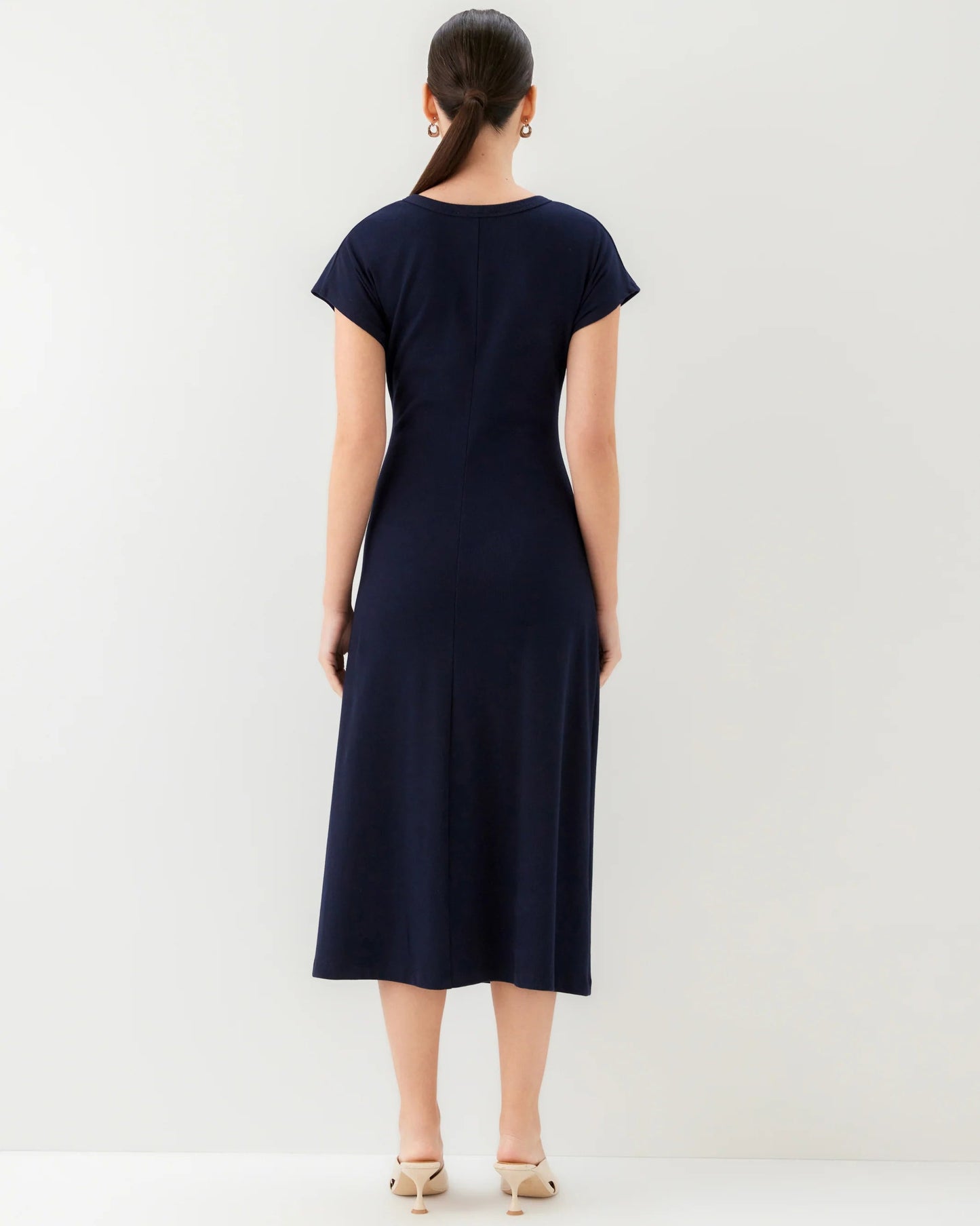Woman wearing a navy blue dress against a white background