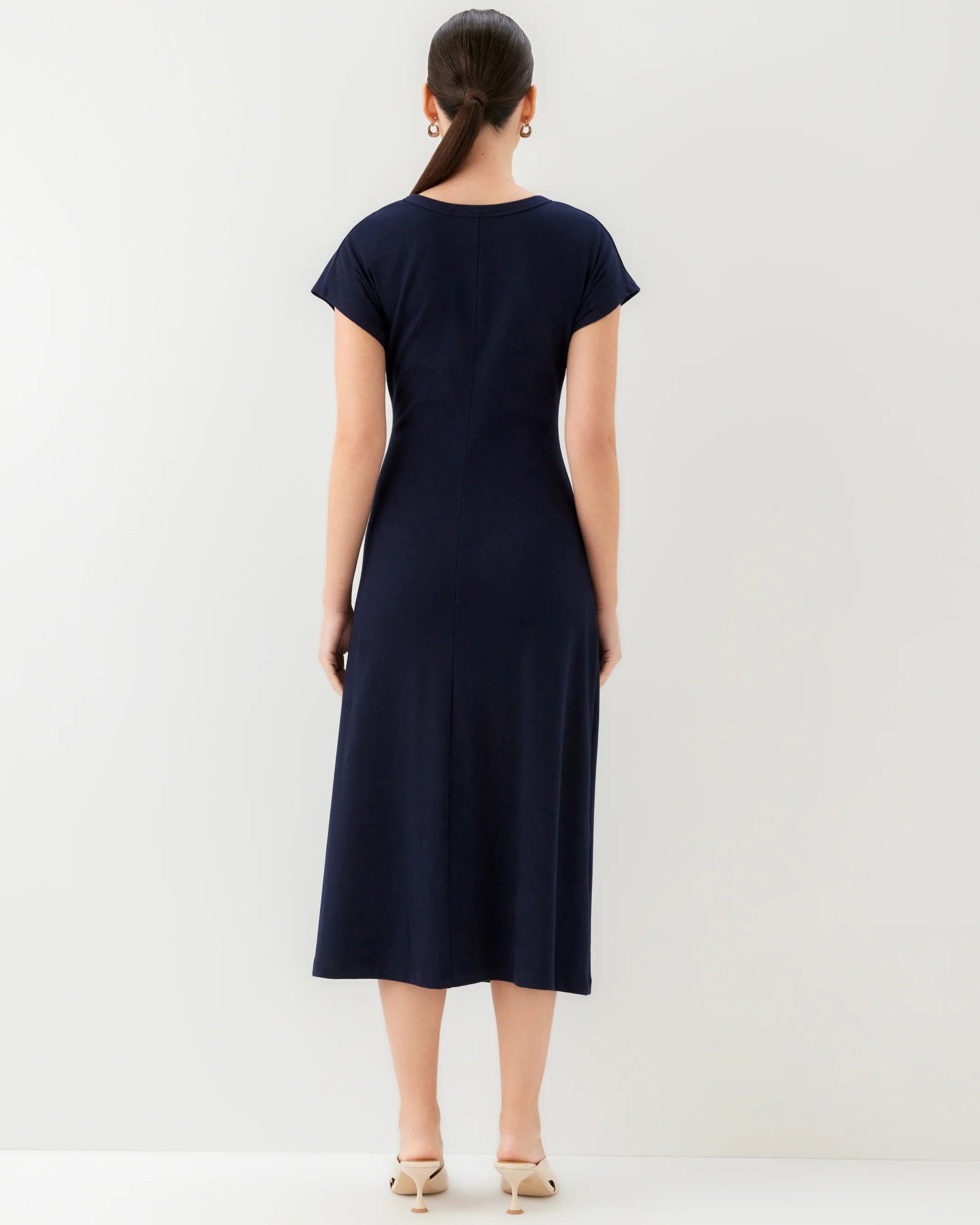 Woman wearing a navy blue dress against a white background