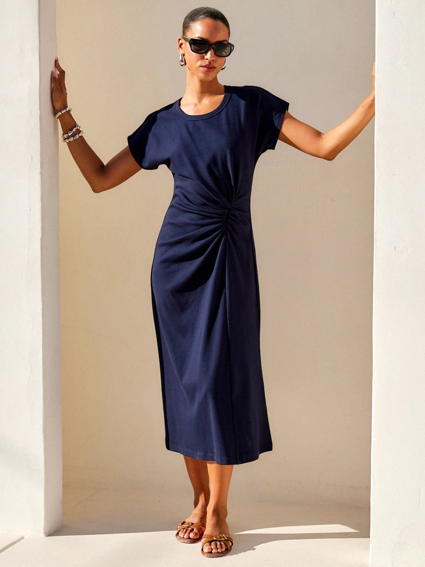 Woman wearing a navy blue dress with a plain background