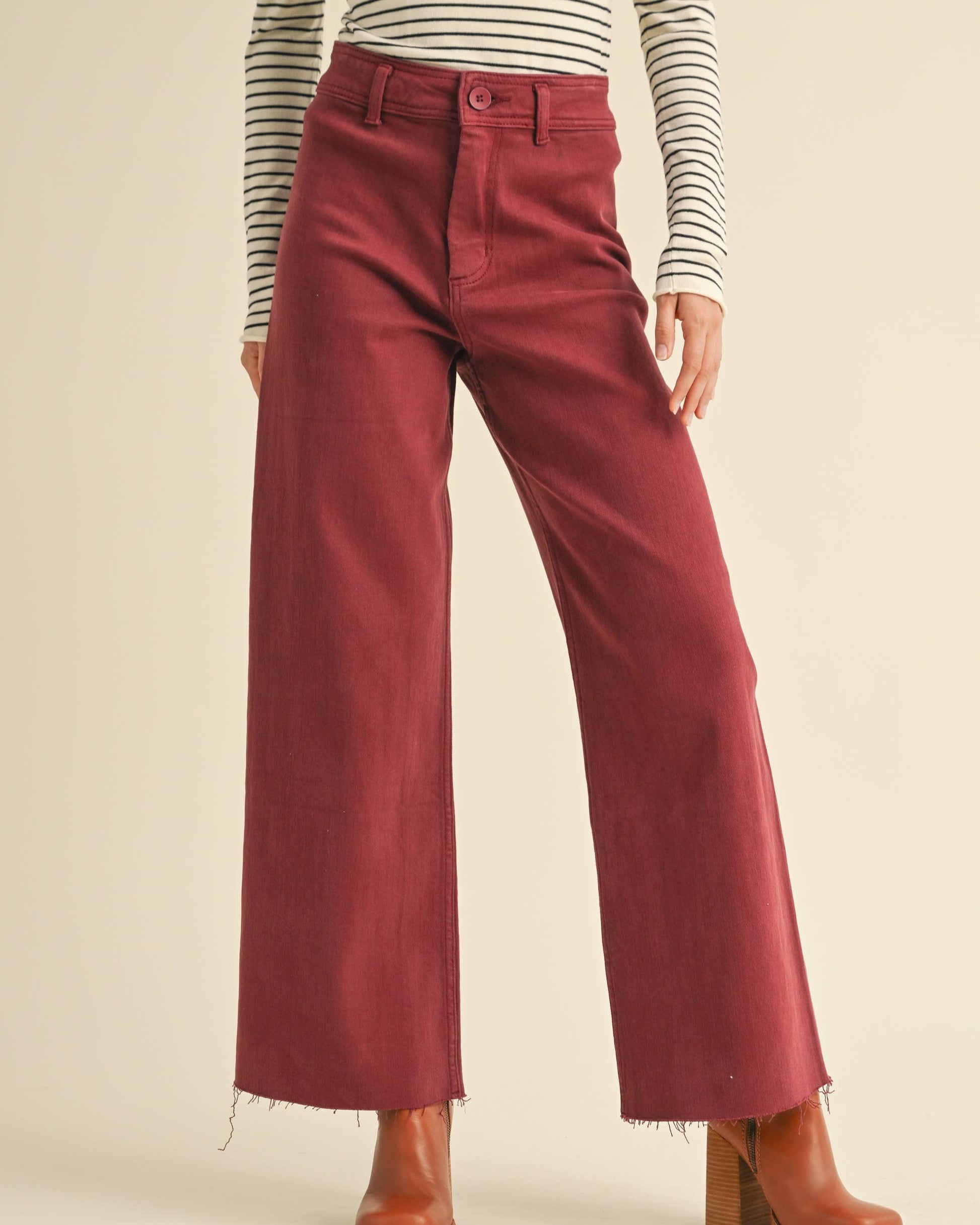 Person wearing red wide-leg pants with a striped shirt on a beige background