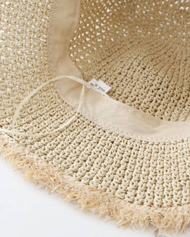Close-up of a beige straw hat with a label on a white background