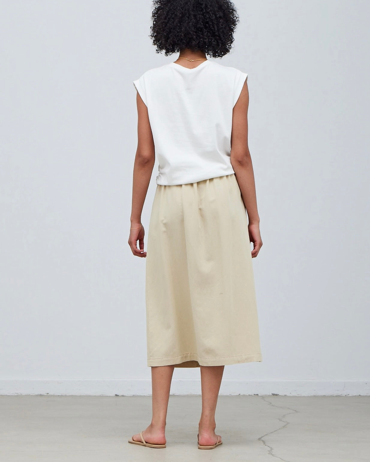 Model wearing Grade & Gather Button Down Midi Skirt in washed natural color wearing white tee on a white background