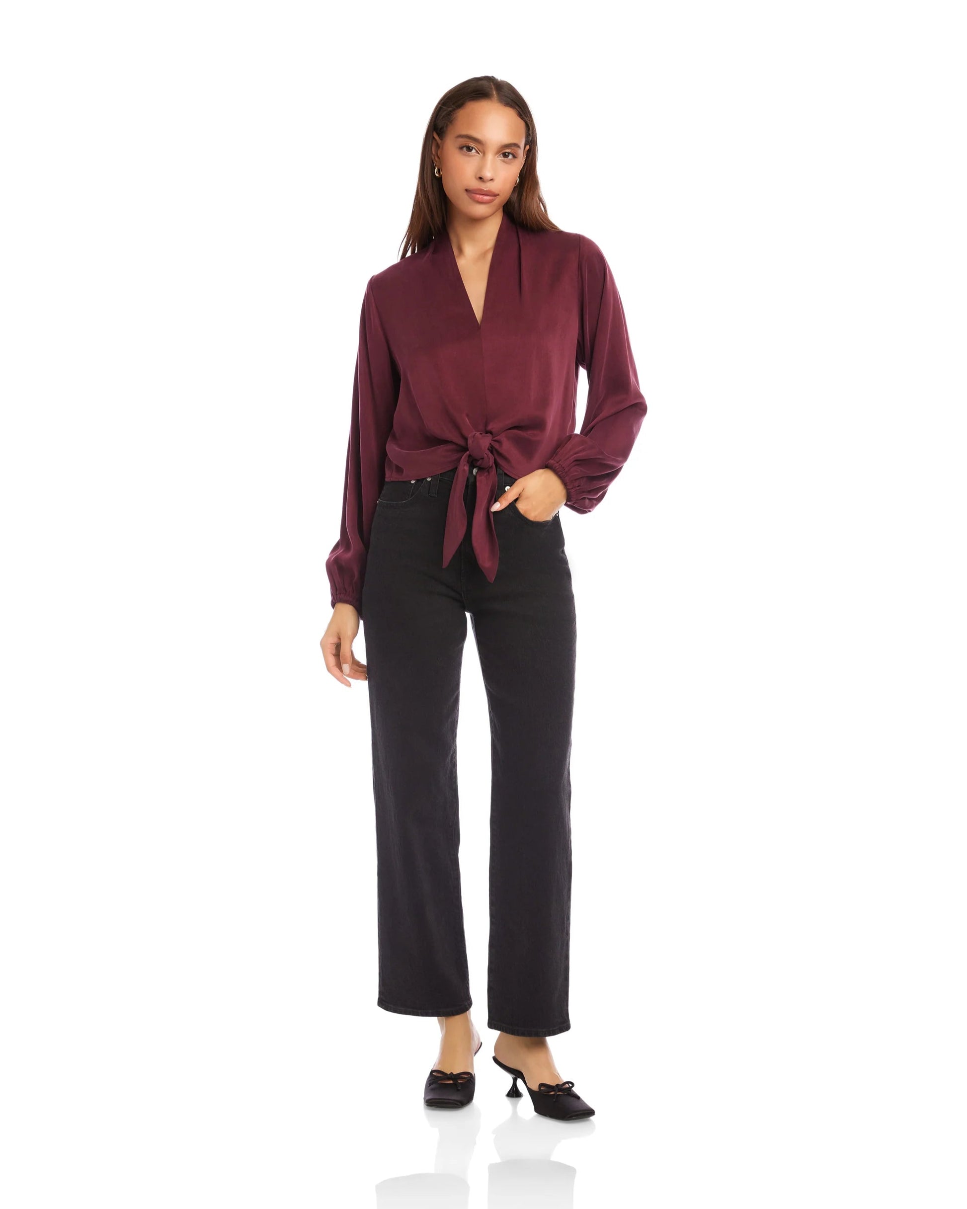 Woman wearing a burgundy blouse and black pants on a white background