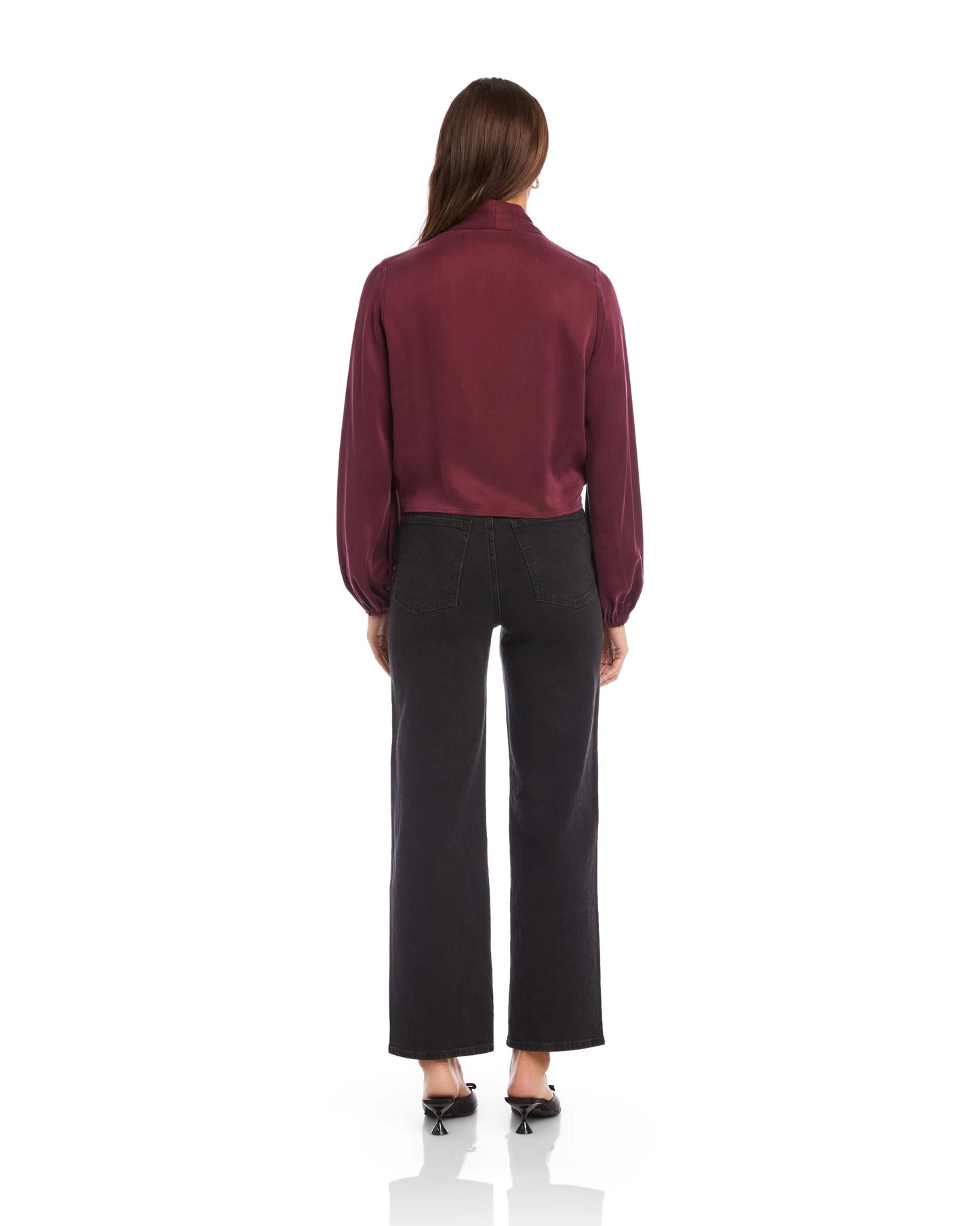 Person wearing a burgundy blouse and black pants on a white background