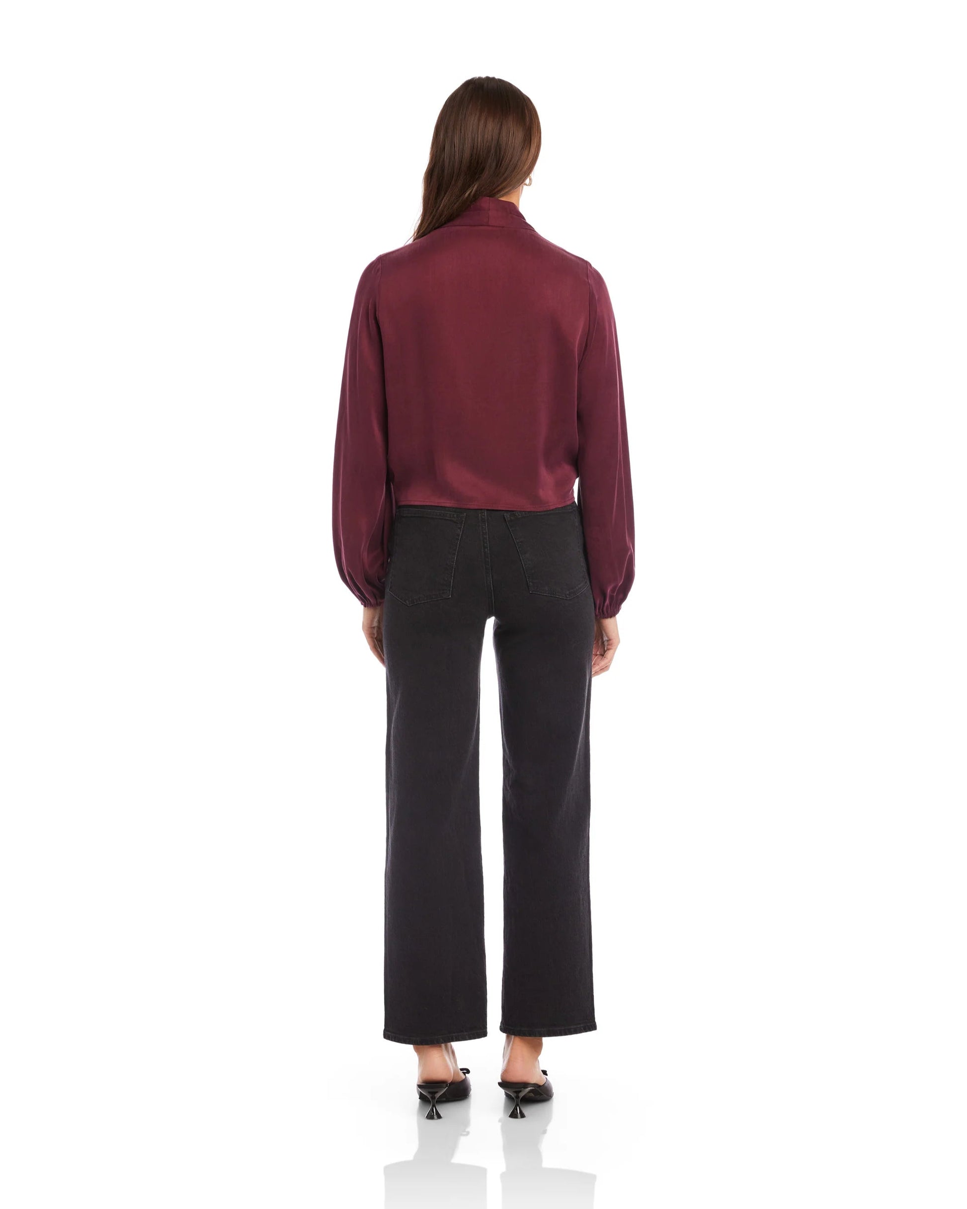 Person wearing a burgundy blouse and black pants on a white background