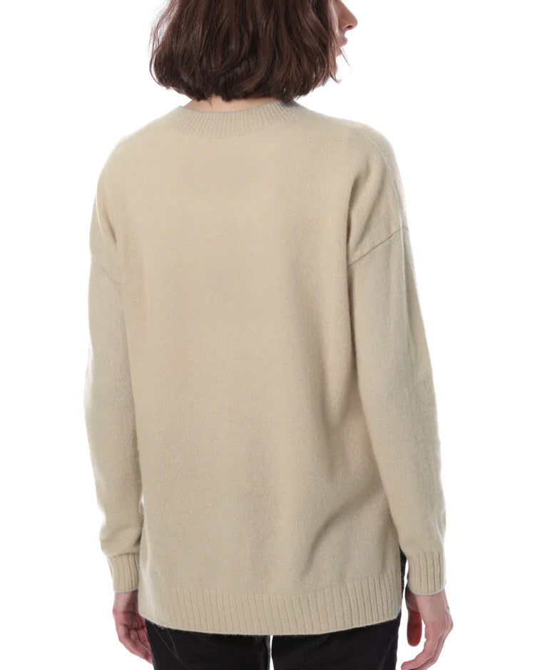 Person wearing a beige sweater on a white background