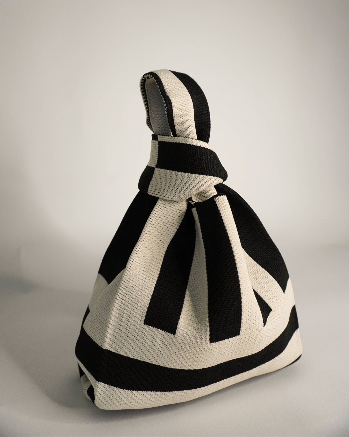 Black and white knitted bag on a gray background