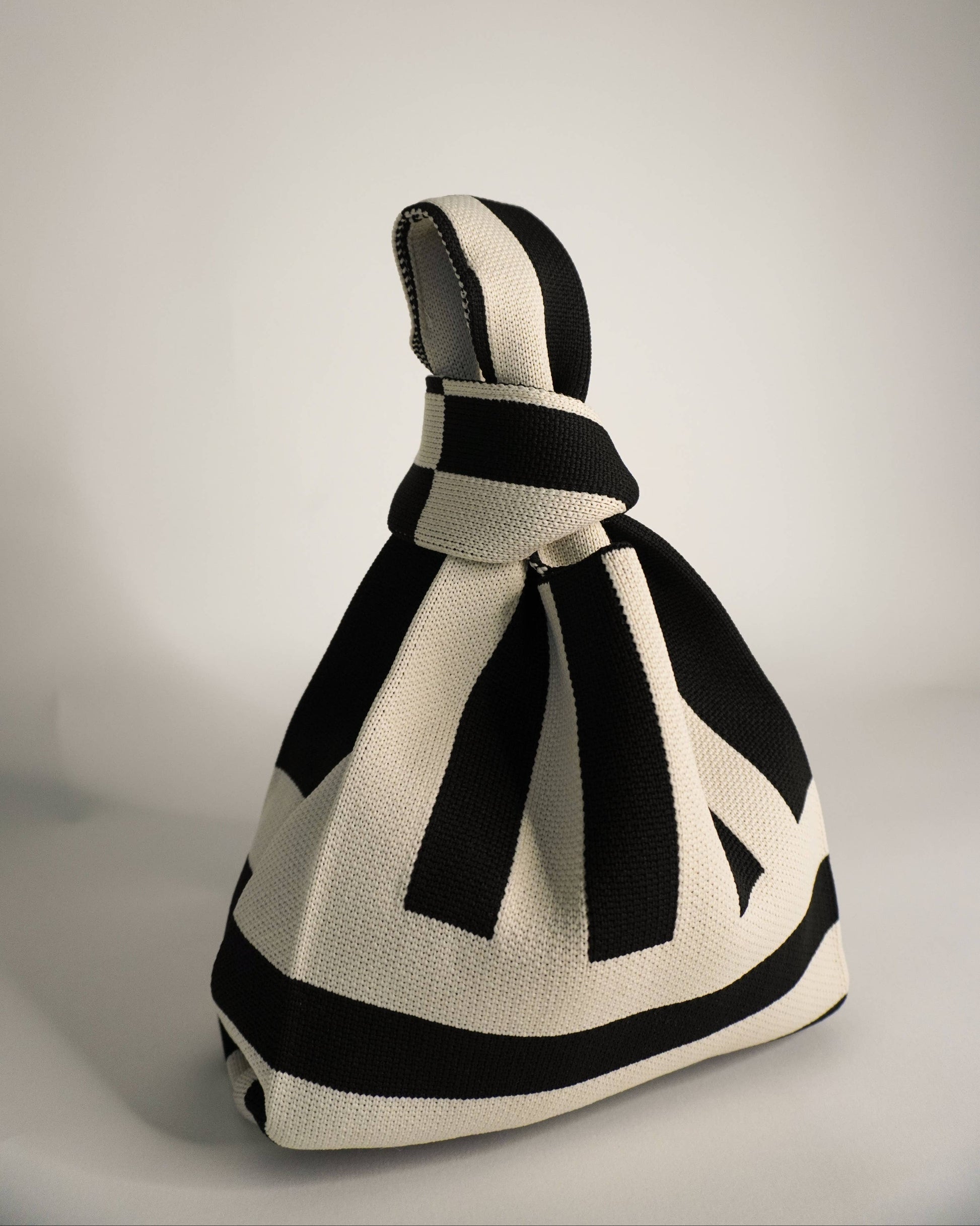 Black and white knitted bag on a gray background