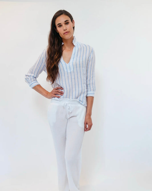 Model is wearing STARKx Annette Top in color White Stripe and wearing white pants on a white background