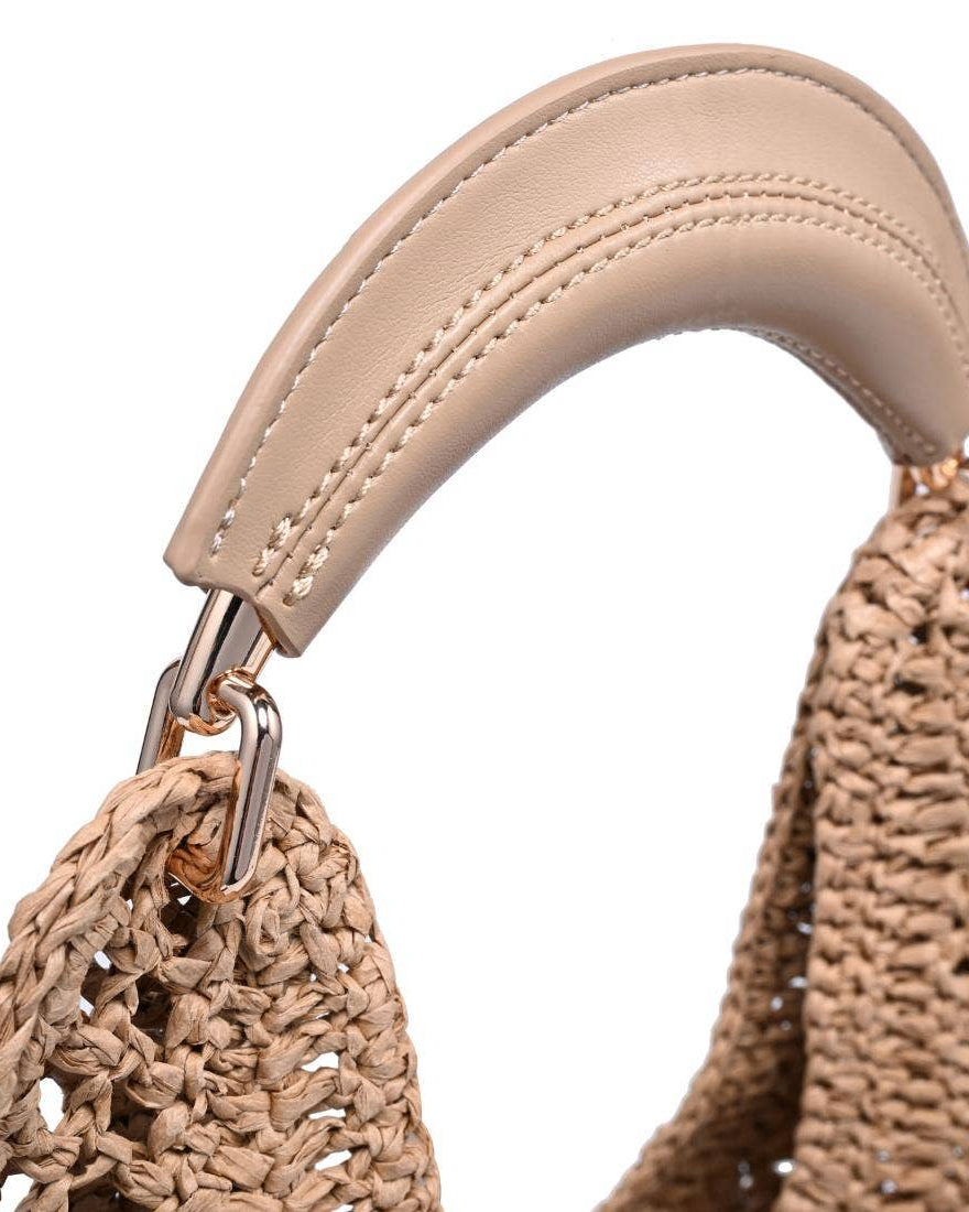 Close-up of a woven handbag with a beige handle on a white background