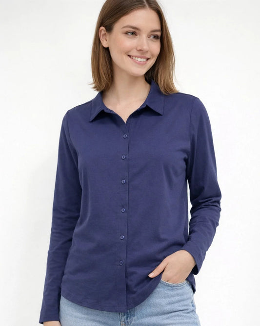 Woman wearing a purple button-up shirt and light blue jeans on a white background