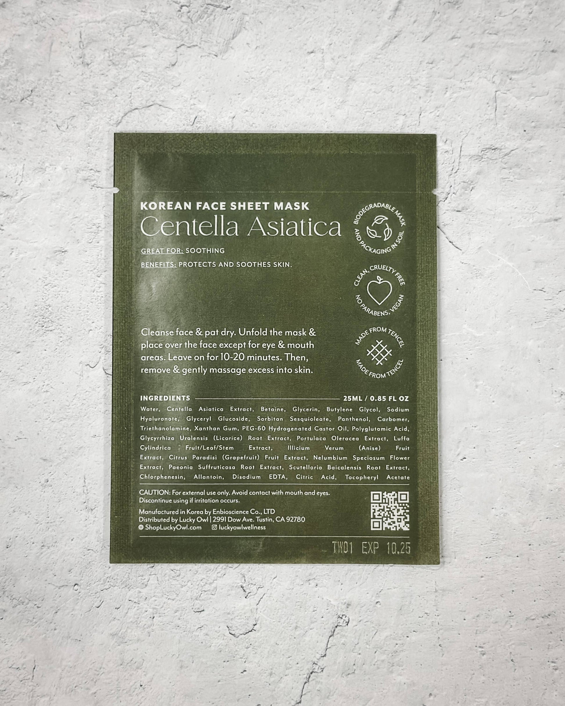 Korean face sheet mask packaging with green label on a textured gray background