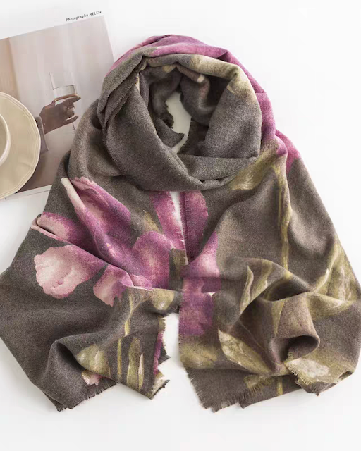 Floral patterned scarf on a white surface with a magazine and cup in the background