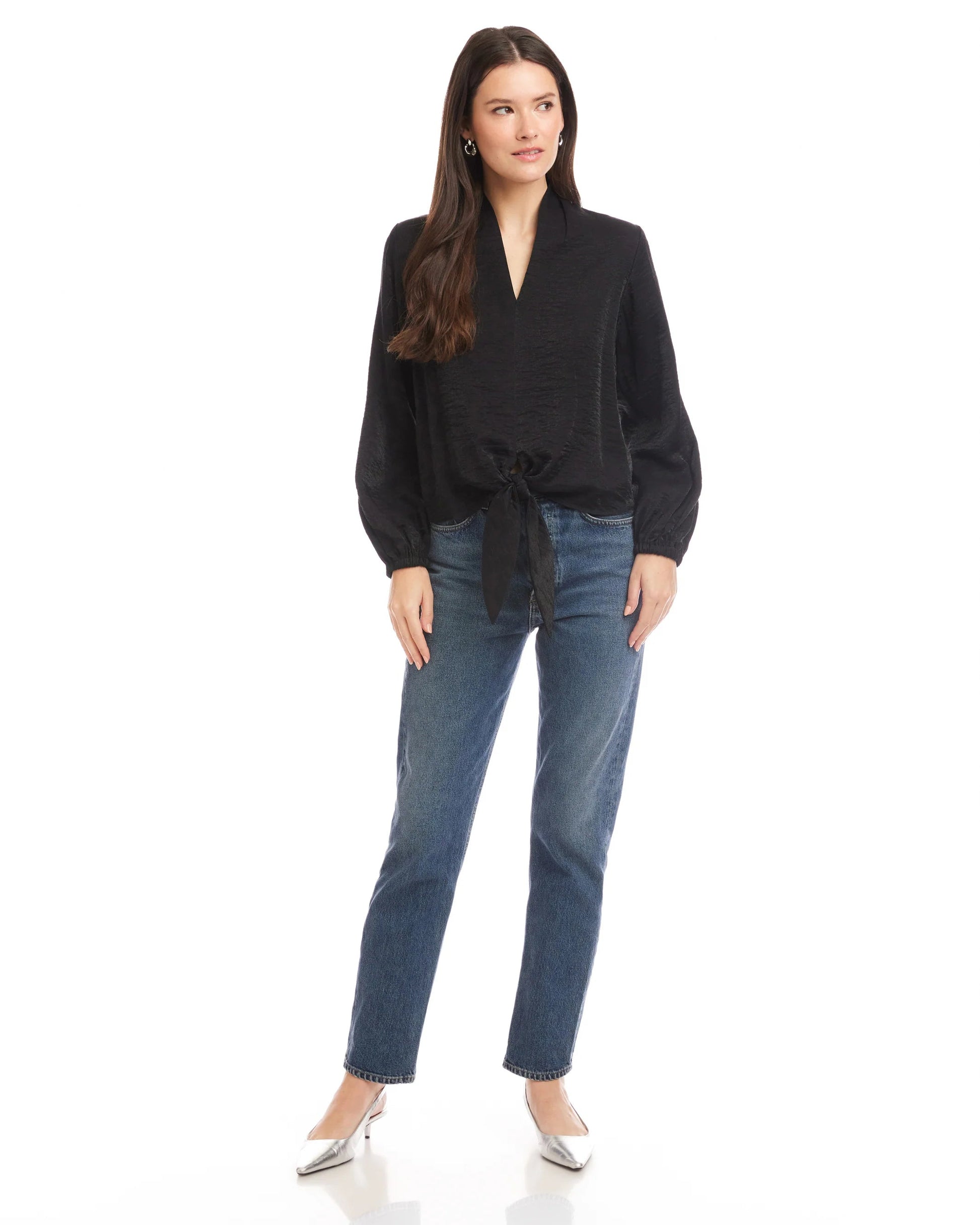 Woman wearing a black top and blue jeans on a white background
