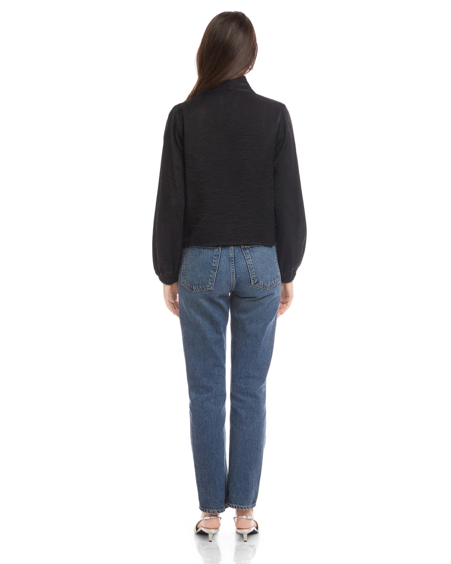 Person wearing a black jacket and blue jeans on a white background