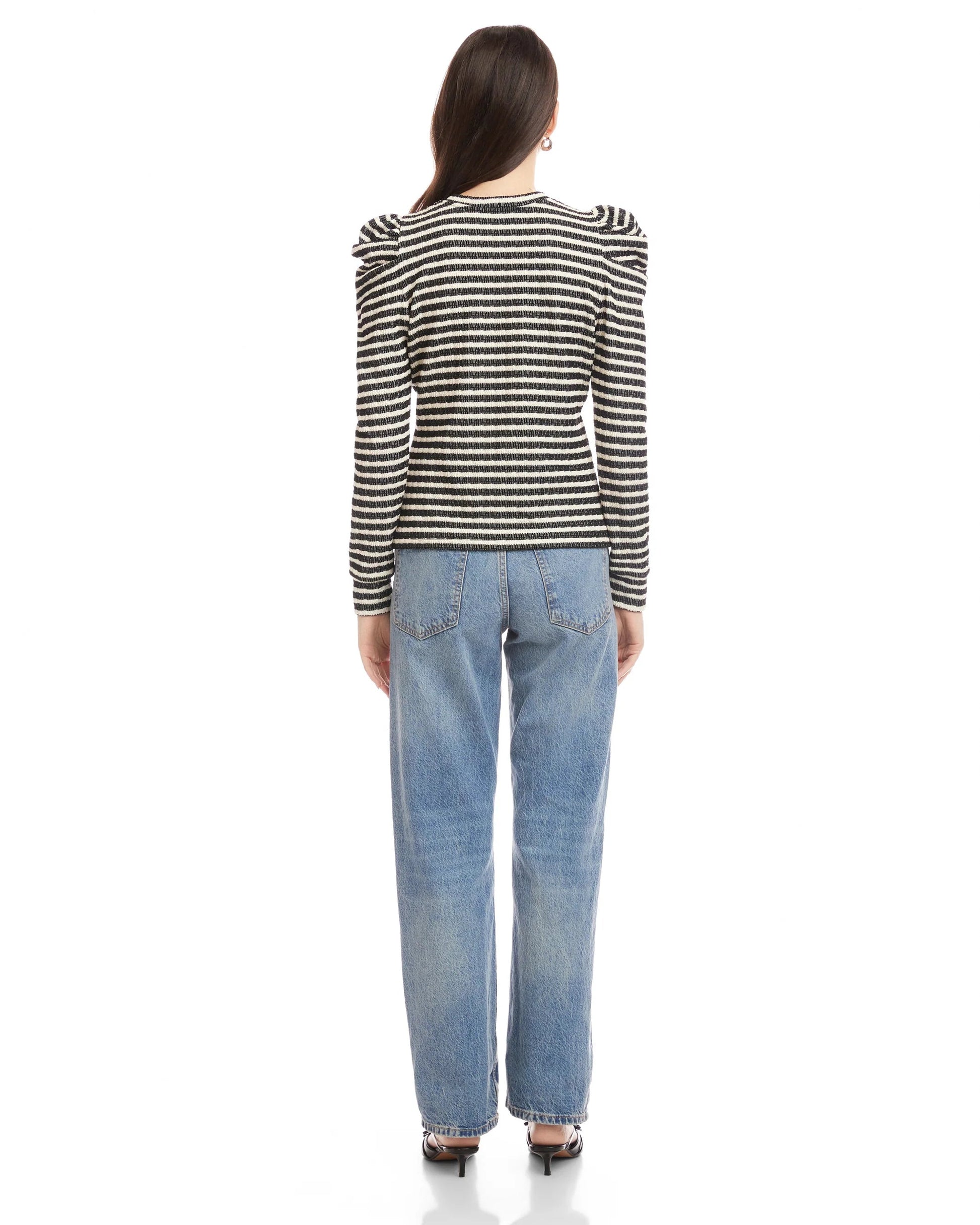 Person wearing a striped shirt and blue jeans on a white background