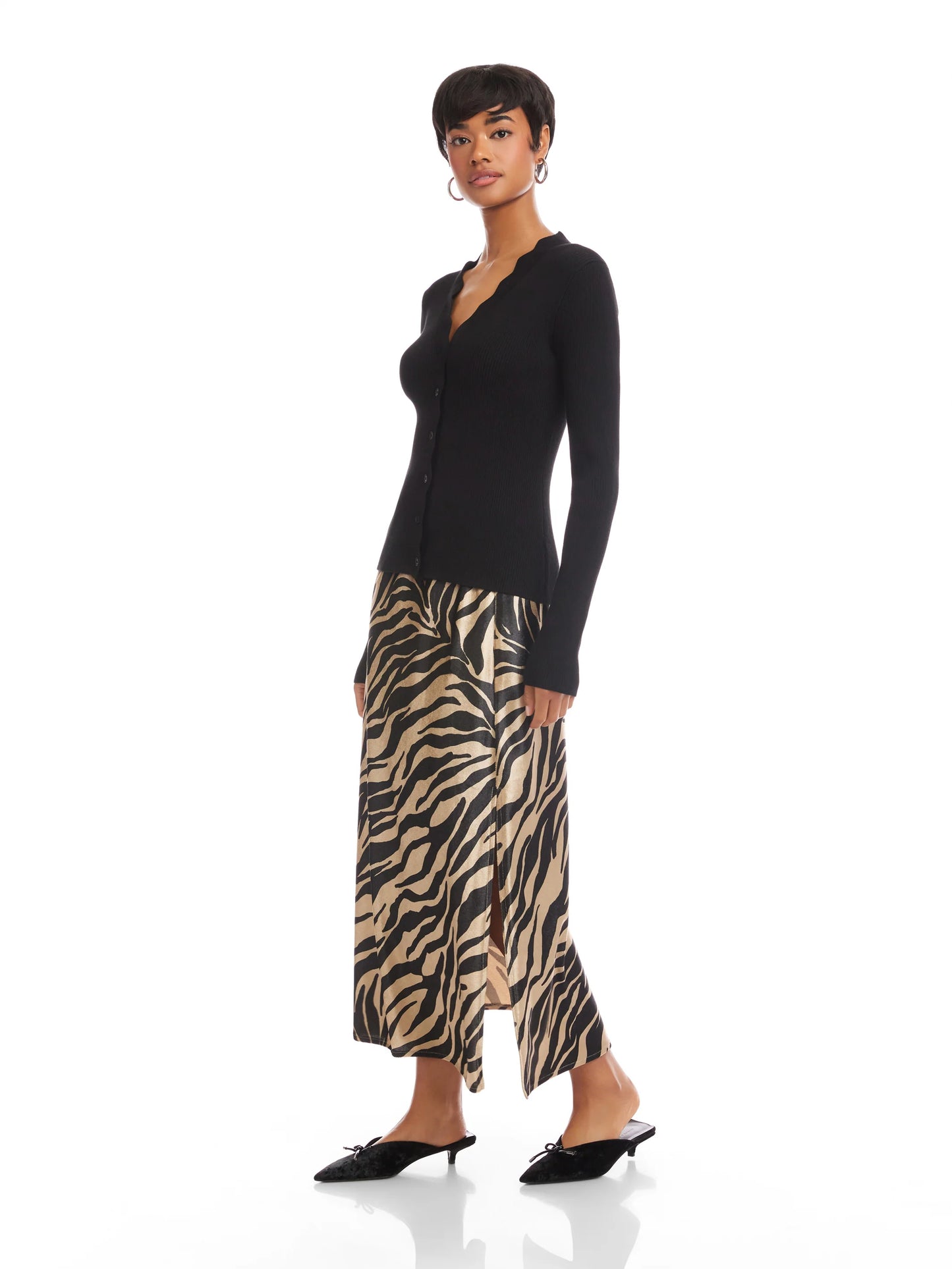 Woman wearing a black long-sleeve top and zebra print skirt on a white background