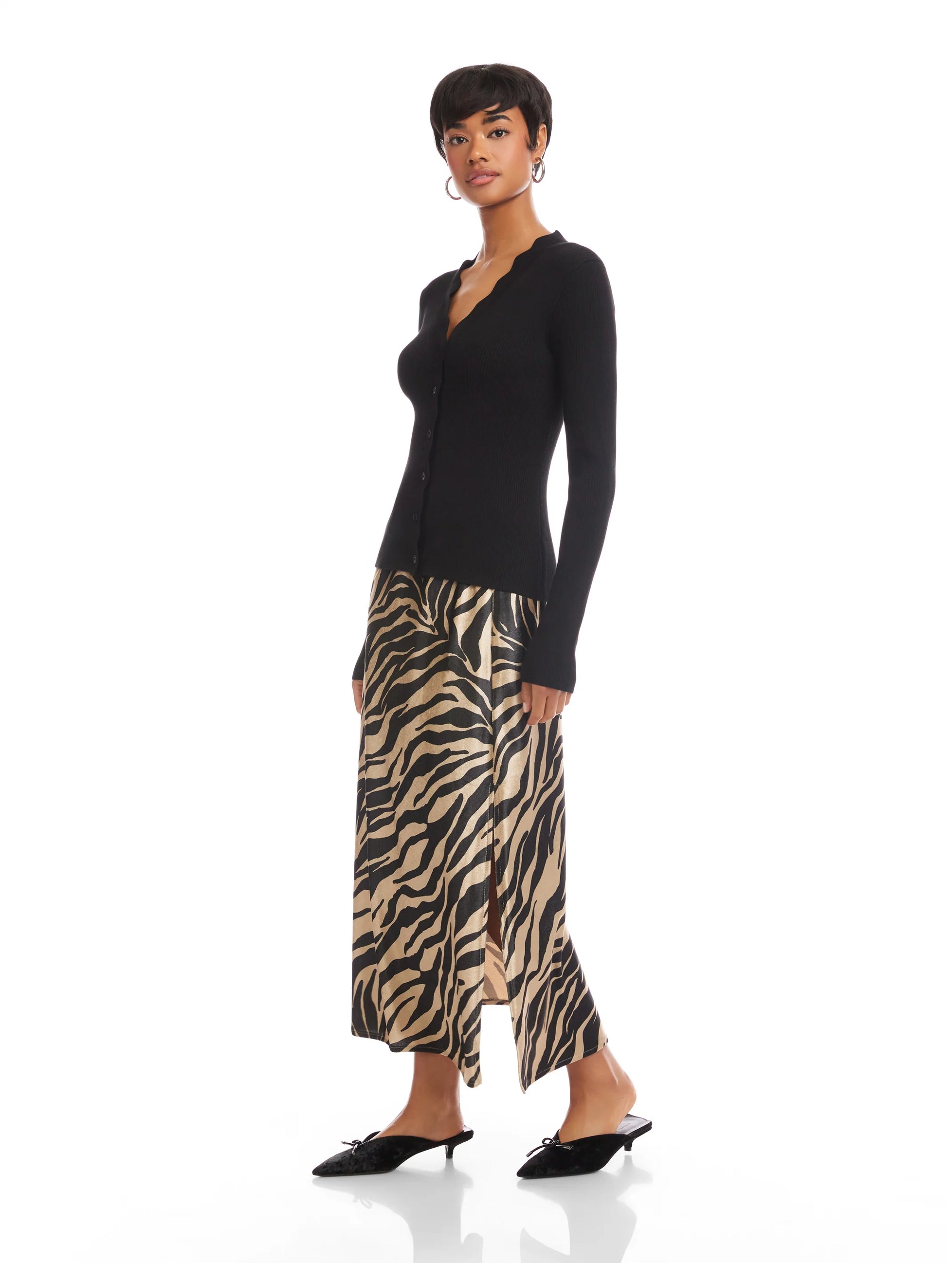 Woman wearing a black long-sleeve top and zebra print skirt on a white background