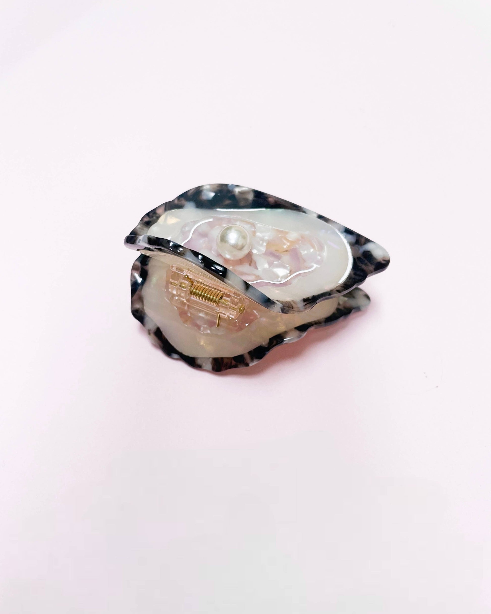 Side view of an oyster hair clip resting on a white background