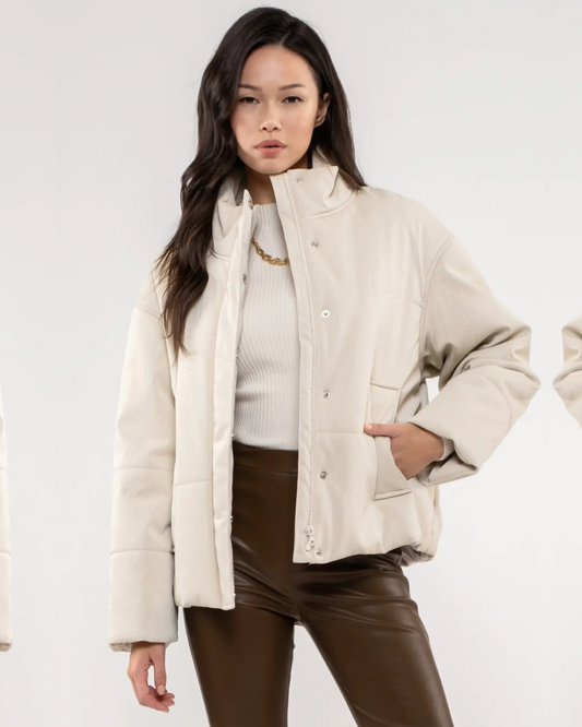 Model wearing Moon River High Neck Faux Leather Jacket Beige wearing brown pants on a white background