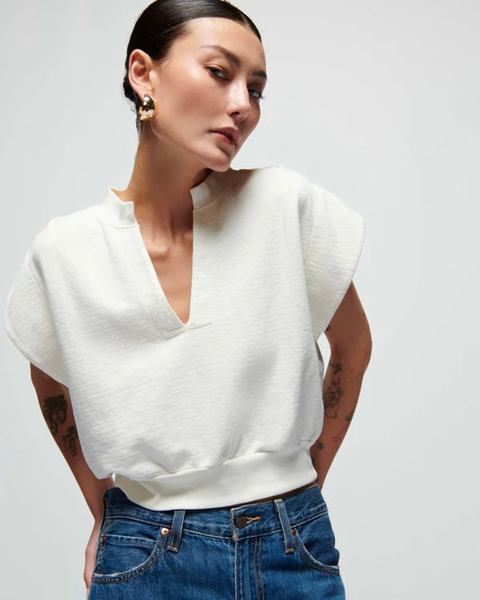 Model wearing Nation Lenon crewneck sweatshirt and jeans posing in front of a white background.