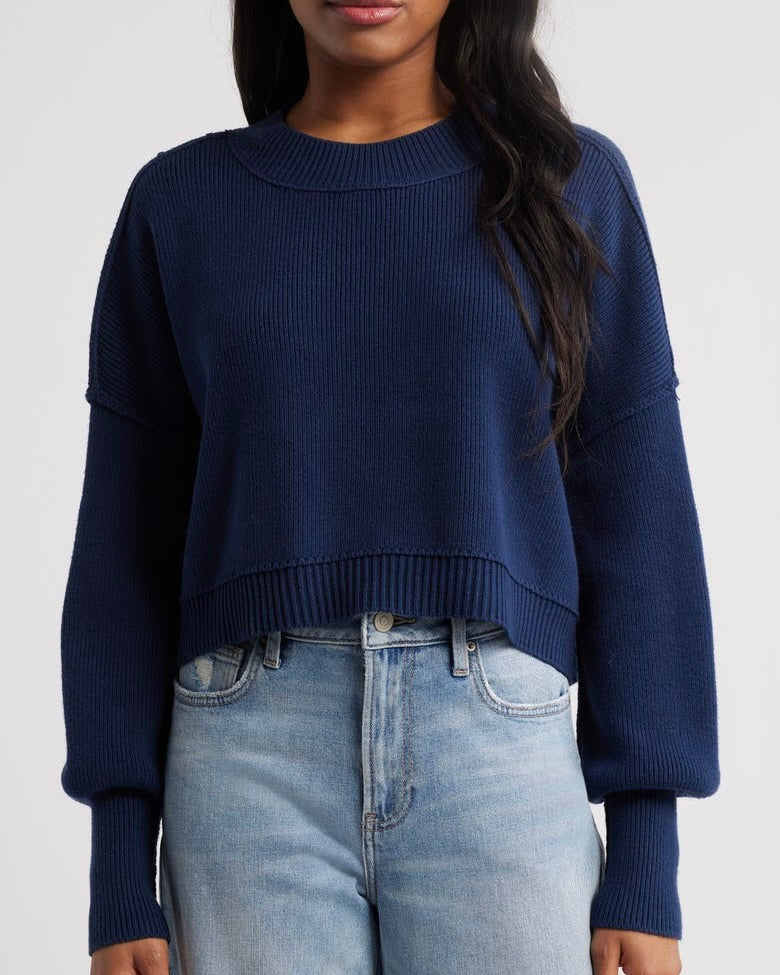 Model wearing the Free People Easy Street crop pullover sweater in navy standing against a white background.