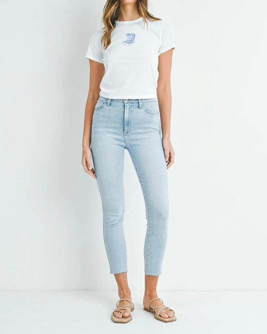 Model wearing Just Black Denim HR Curvy Stretchy Skinny jeans wearing white tee and sandals on a white background