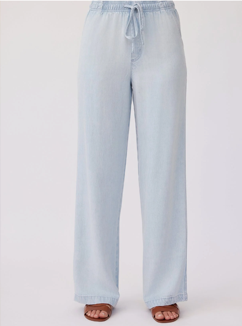 Model is wearing Bella Dahl Drawstring Pant in color Oasis Spray Wash with  brown leather sandals on a white background