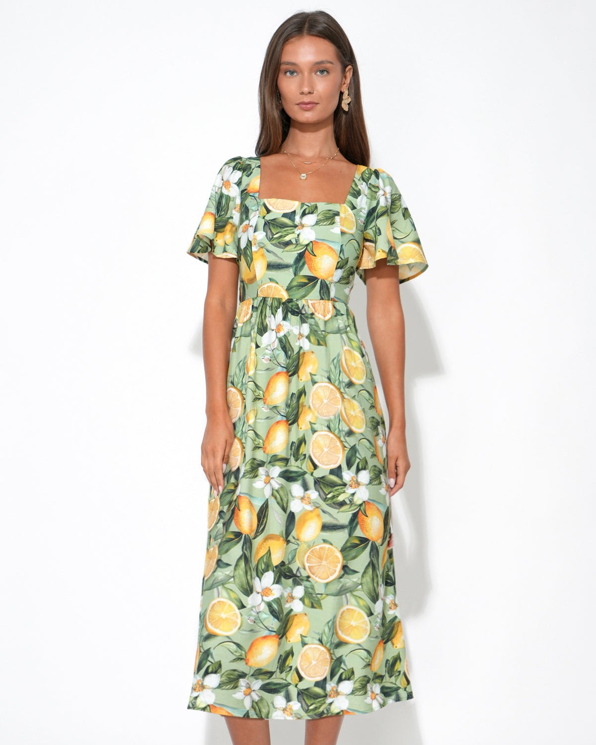 Woman wearing a floral dress with lemon pattern on a white background