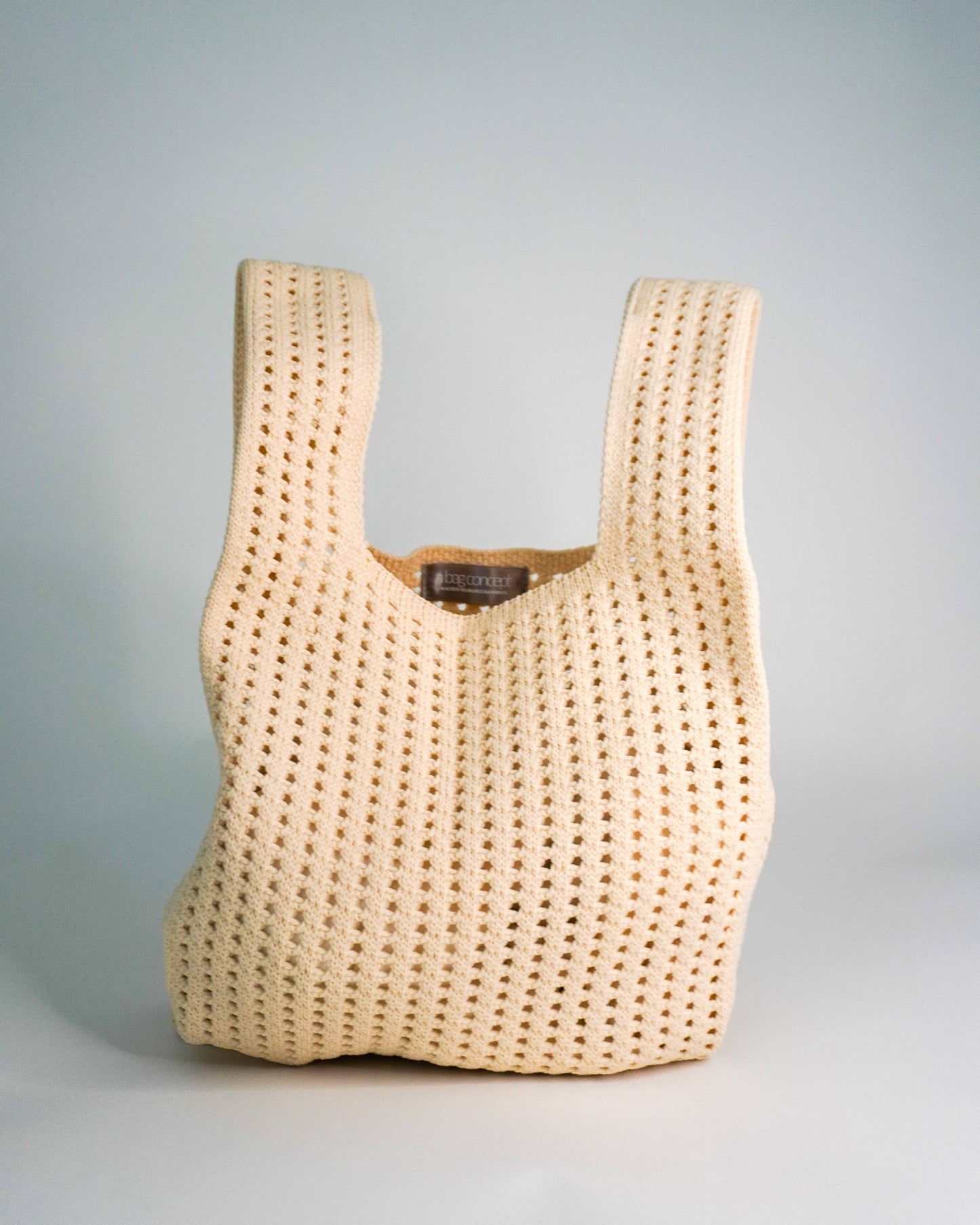 Beige woven handbag on a light gray background