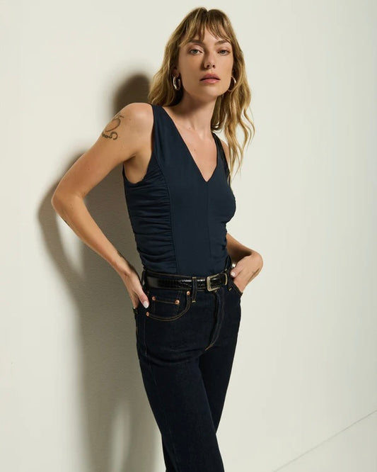 Front view of a model wearing the Nation Shawna tank with dark blue posing in front of a white wall.