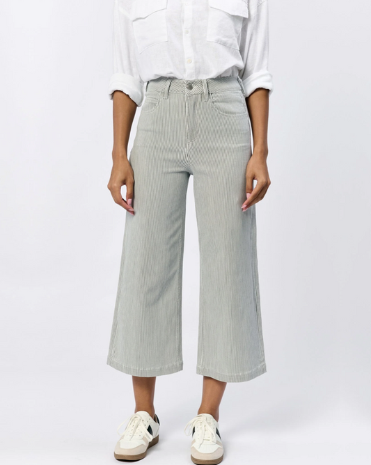 Front view of the Dear John Denim Audrey wide leg jean in Railroad grey on a model wearing a white shirt and sneakers standing in front of a white background.