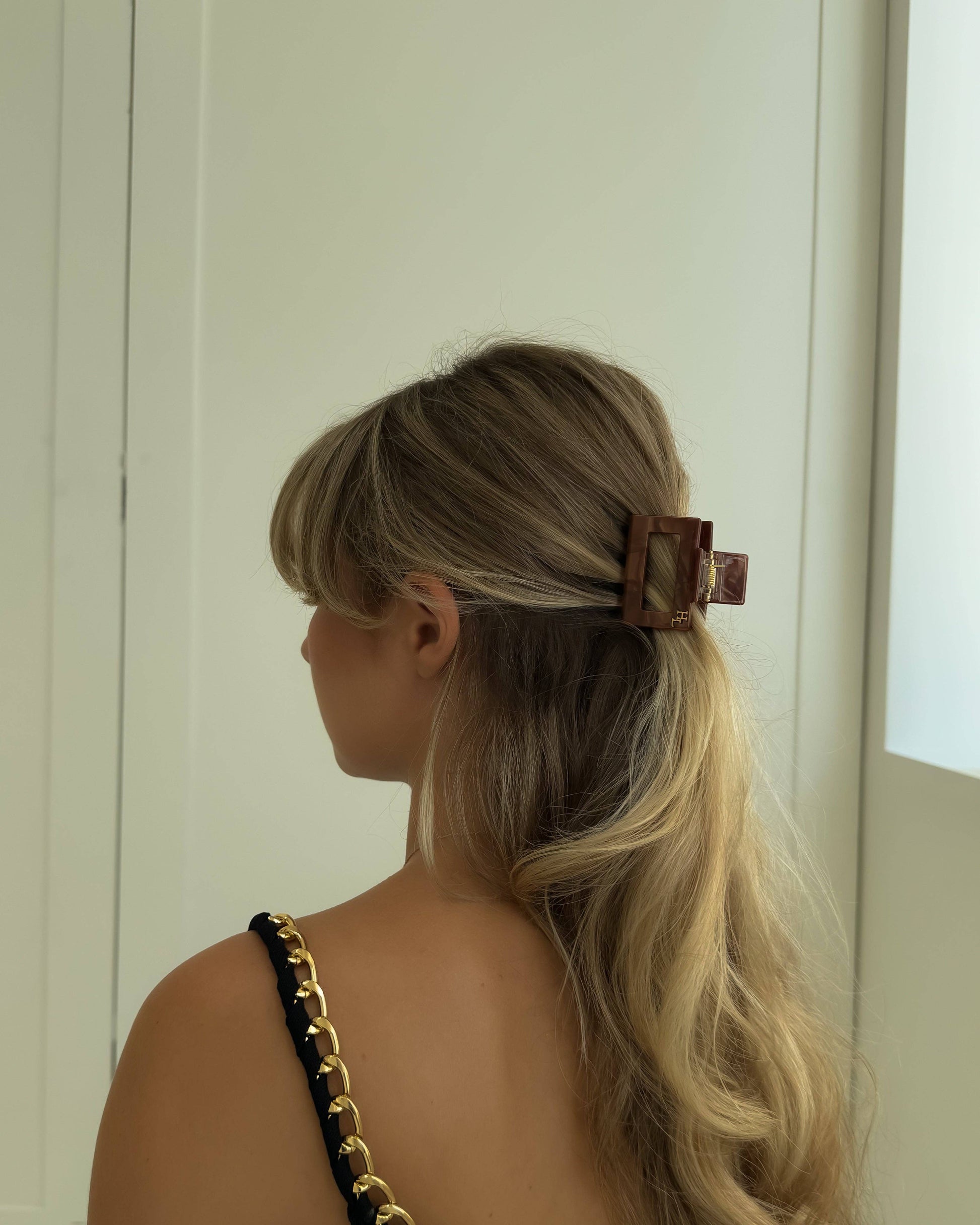 Back view of woman wearing the HoneyLux Ecofriendly Acetate Midi Clip in Hazel against a neutral background.