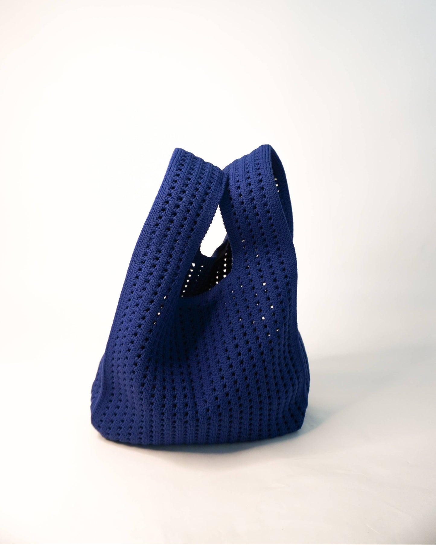 Blue woven handbag on a white background