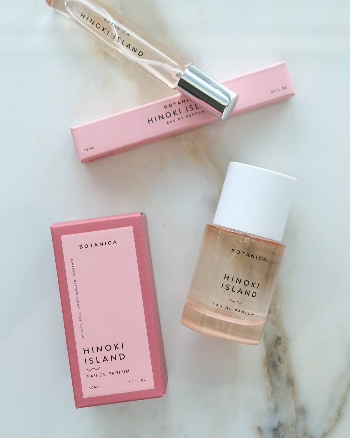 Botanica Hinoki Island perfume bottle and packaging on a marble surface