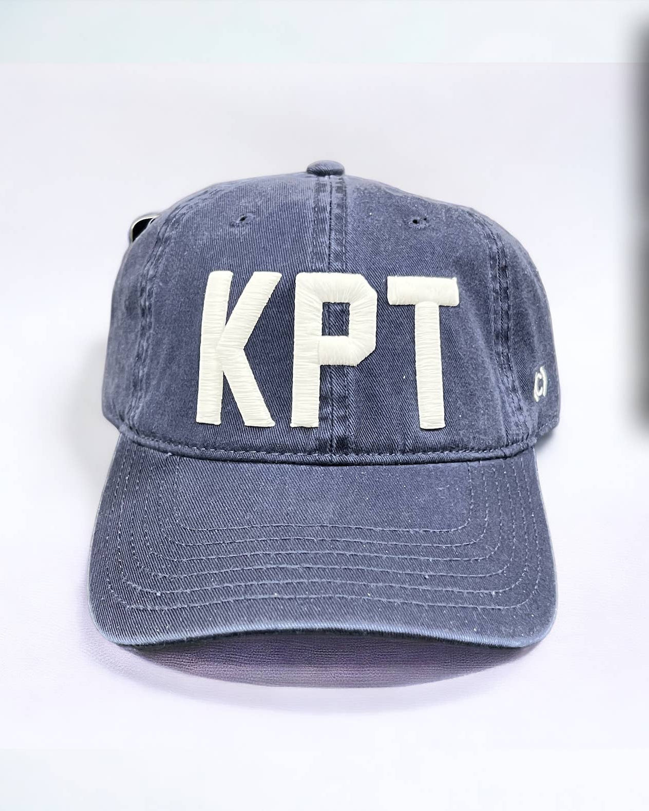 Blue cap with 'KPT' on a white background