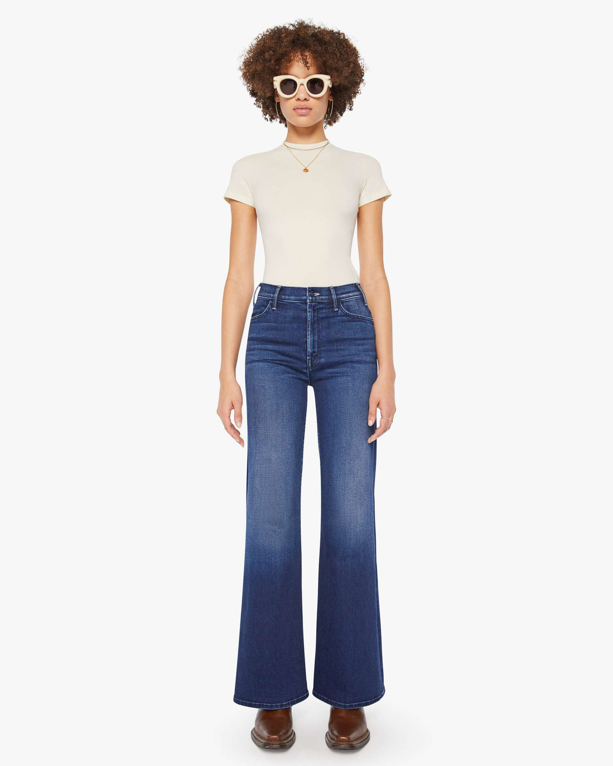 Person wearing a white t-shirt and blue jeans on a white background