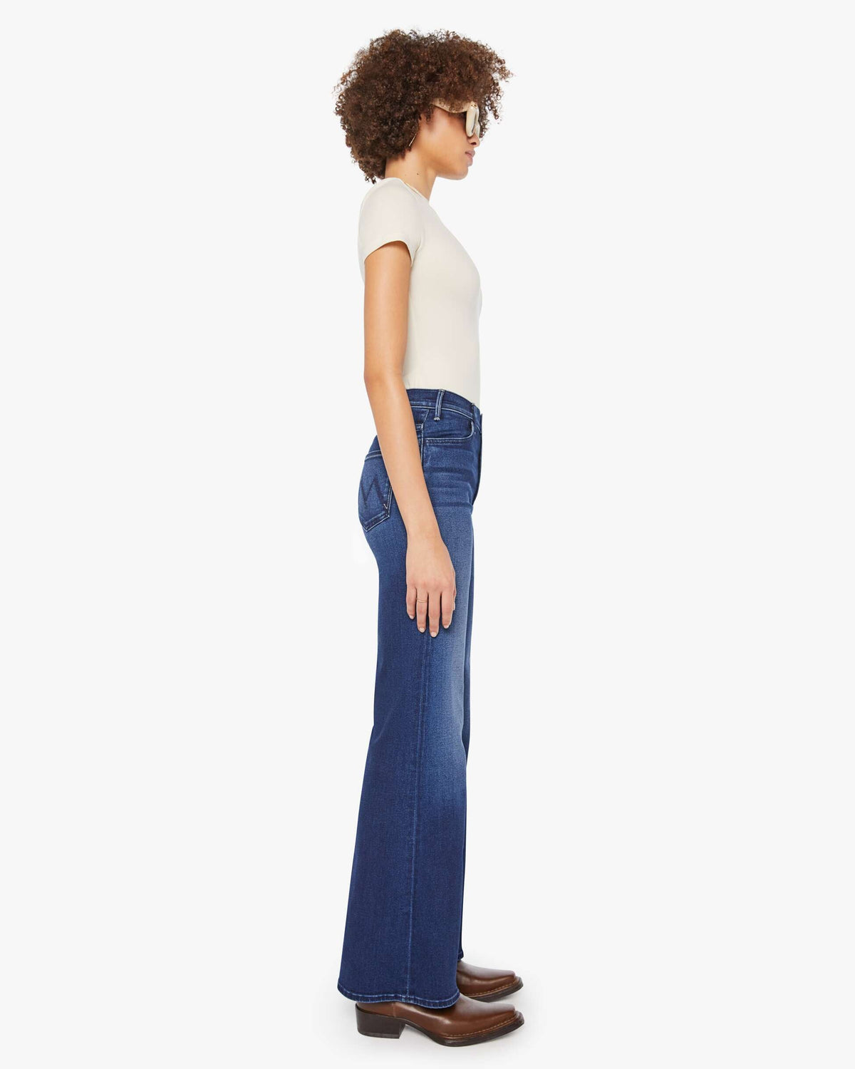 Woman wearing blue jeans and a white top on a white background