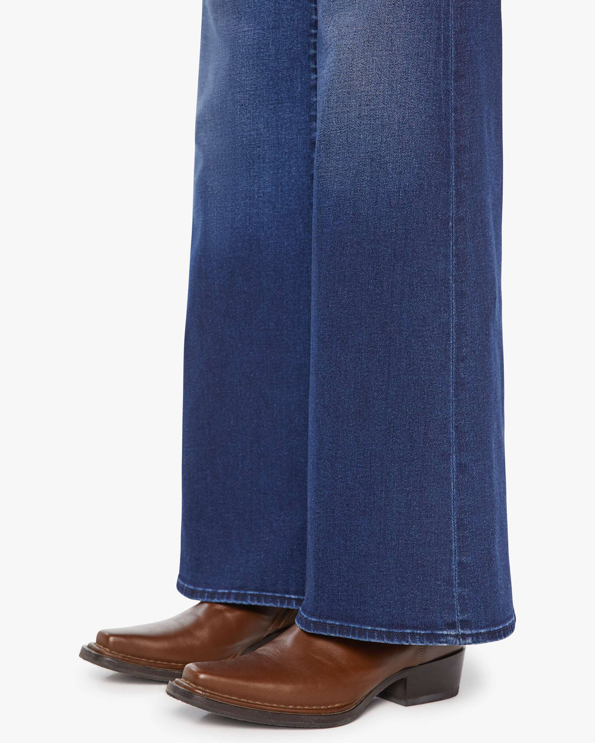Blue jeans with brown boots on a white background