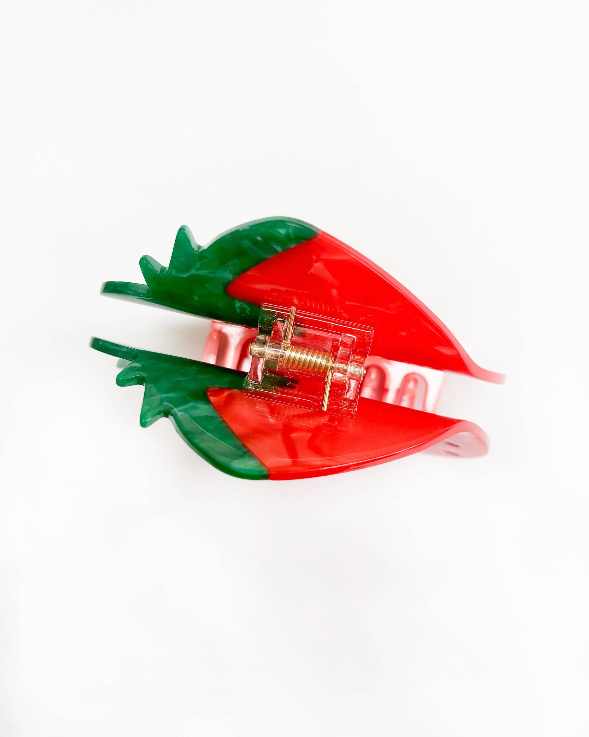 Red and green hair clip on a white background