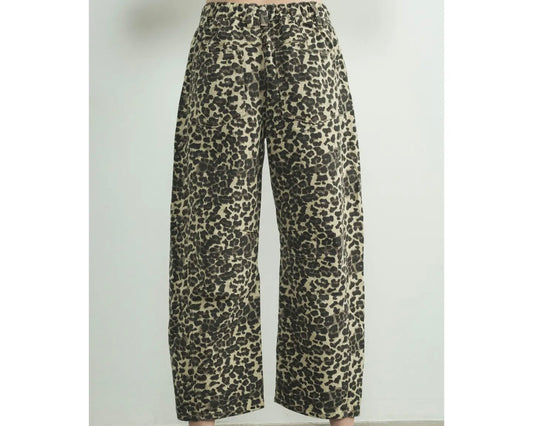 Back view of a model wearing a relaxed fit denim pant in leopard animal print on a white background.