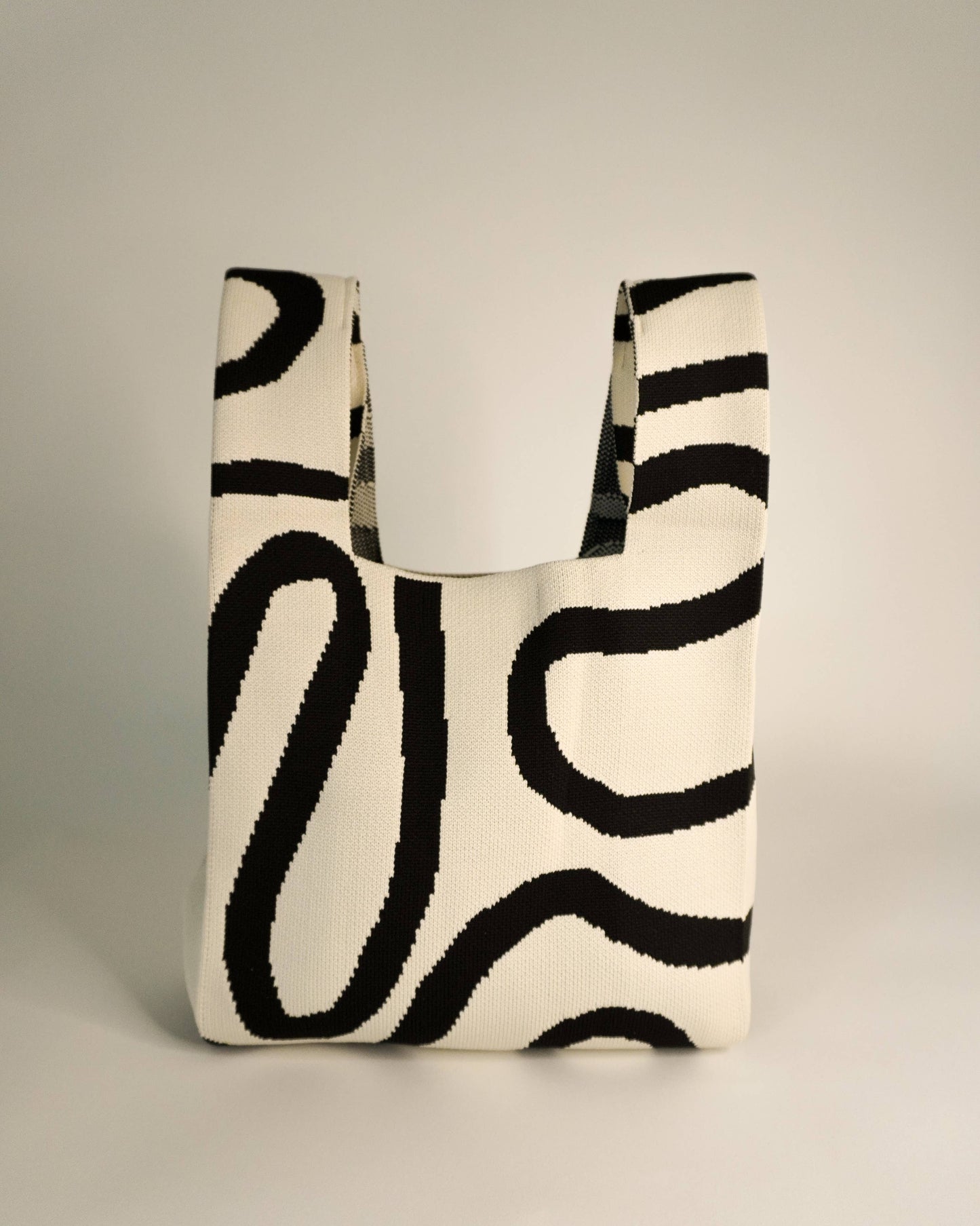 Tote bag with black abstract pattern on a neutral background