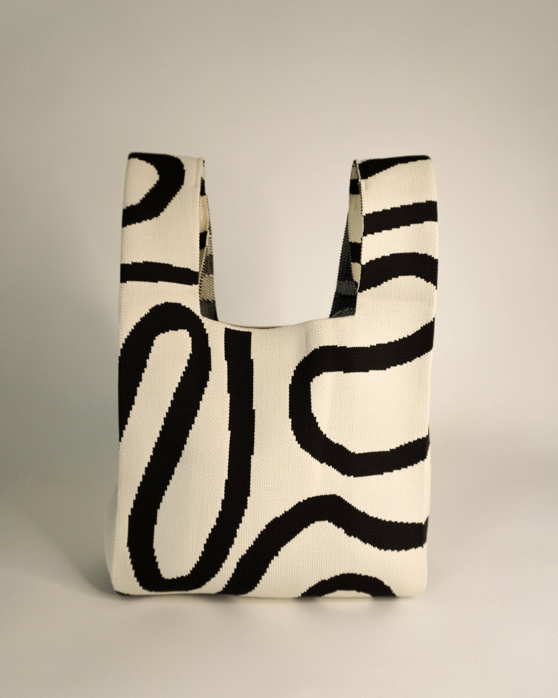 Tote bag with black abstract pattern on a neutral background